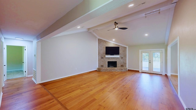 15269 County Road 1227, Flint, TX 75762 - unfurnished living room with a ceiling fan, light wood-style flooring, a fireplace, and french doors