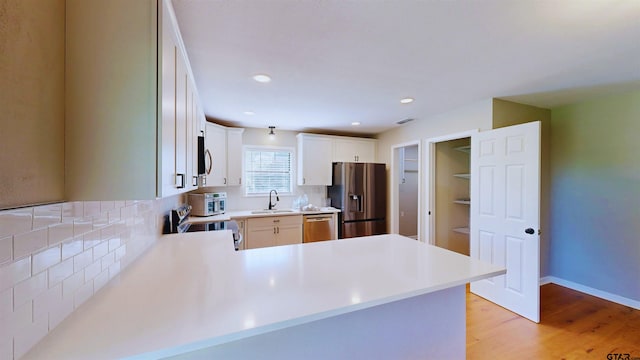 15269 County Road 1227, Flint, TX 75762 - kitchen featuring appliances with stainless steel finishes, backsplash, light countertops, light wood-style flooring, and recessed lighting