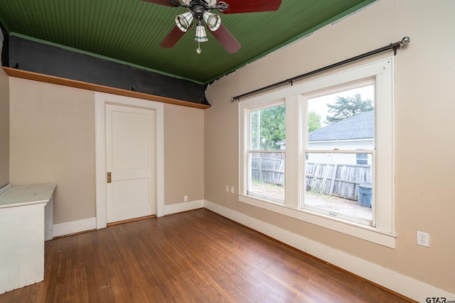 unfurnished room featuring baseboards, ceiling fan, and wood finished floors