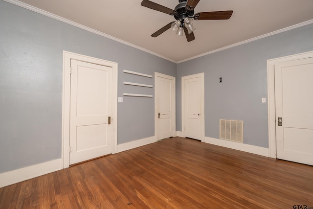 unfurnished bedroom featuring baseboards, ornamental molding, visible vents, and wood finished floors
