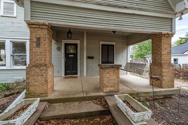view of exterior entry featuring covered porch