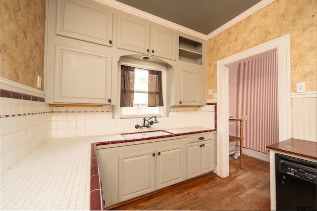kitchen with ornamental molding, wallpapered walls, a sink, a wainscoted wall, and black dishwasher