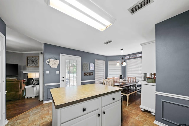 kitchen featuring decorative light fixtures, visible vents, an inviting chandelier, and white cabinetry