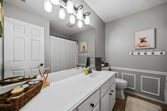 full bathroom with visible vents, toilet, wainscoting, tile patterned flooring, and vanity