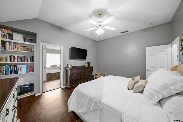 bedroom featuring dark wood-style floors, visible vents, lofted ceiling, ceiling fan, and connected bathroom