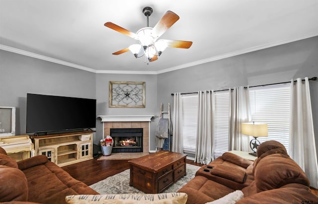 living area featuring ornamental molding, a tile fireplace, ceiling fan, and wood finished floors