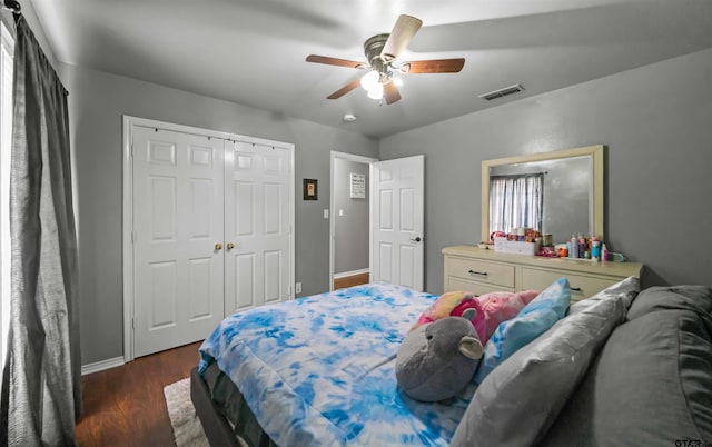 bedroom with visible vents, wood finished floors, a closet, baseboards, and ceiling fan