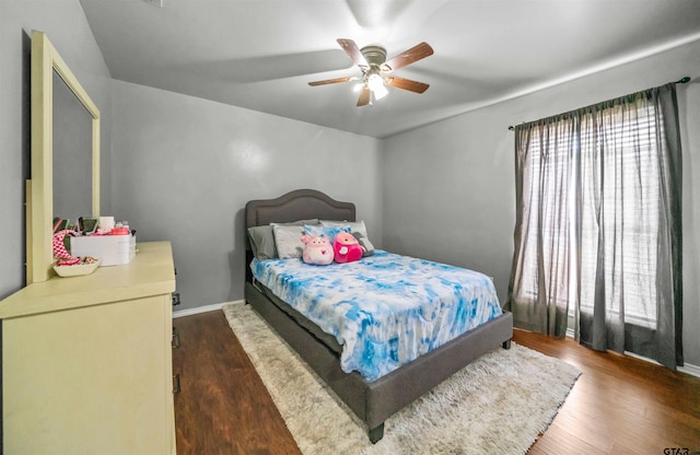 bedroom with baseboards, wood finished floors, and a ceiling fan