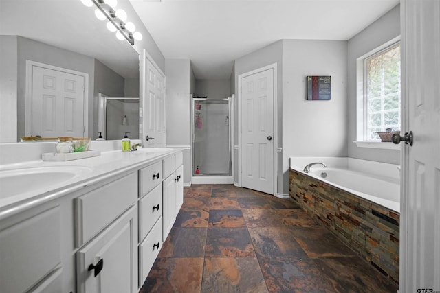 full bath featuring double vanity, a stall shower, a bath, stone finish floor, and a sink