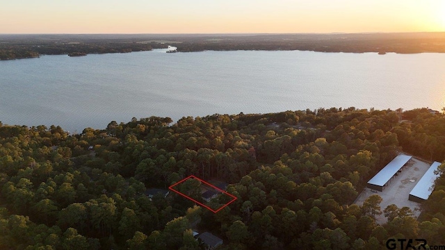 aerial view at dusk featuring a water view