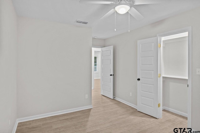 unfurnished bedroom featuring light hardwood / wood-style floors, ceiling fan, and a closet