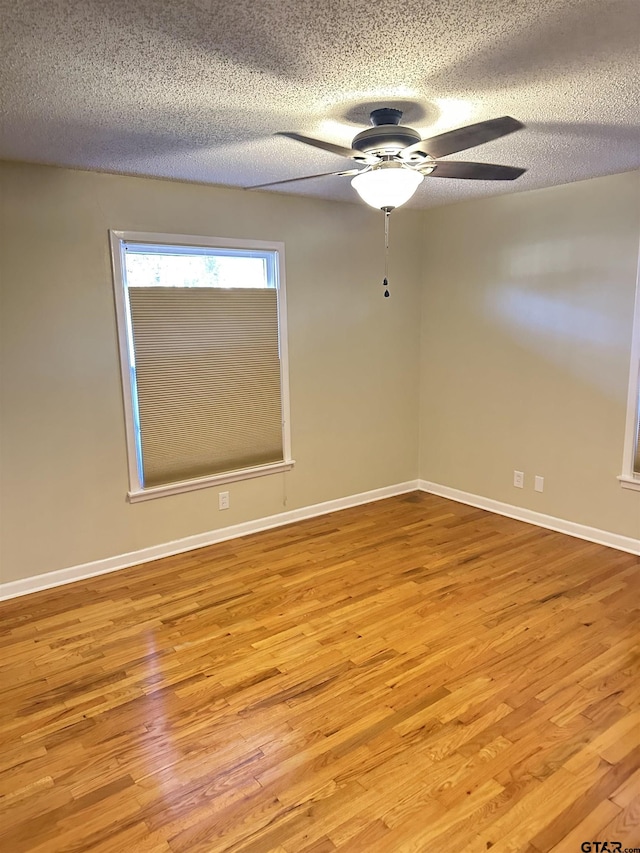 spare room featuring ceiling fan, a textured ceiling, and light wood-type flooring