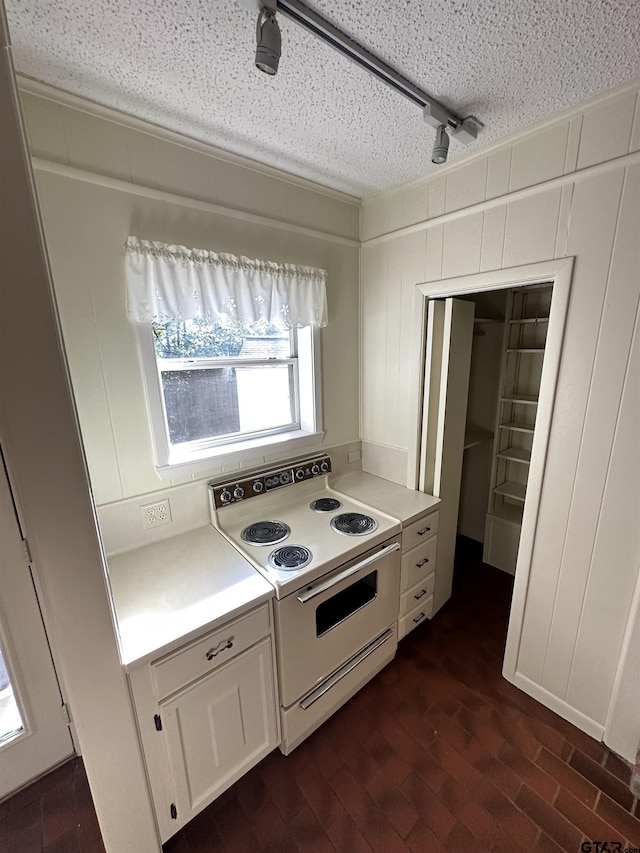 kitchen featuring white cabinets, a textured ceiling, and white range with electric stovetop