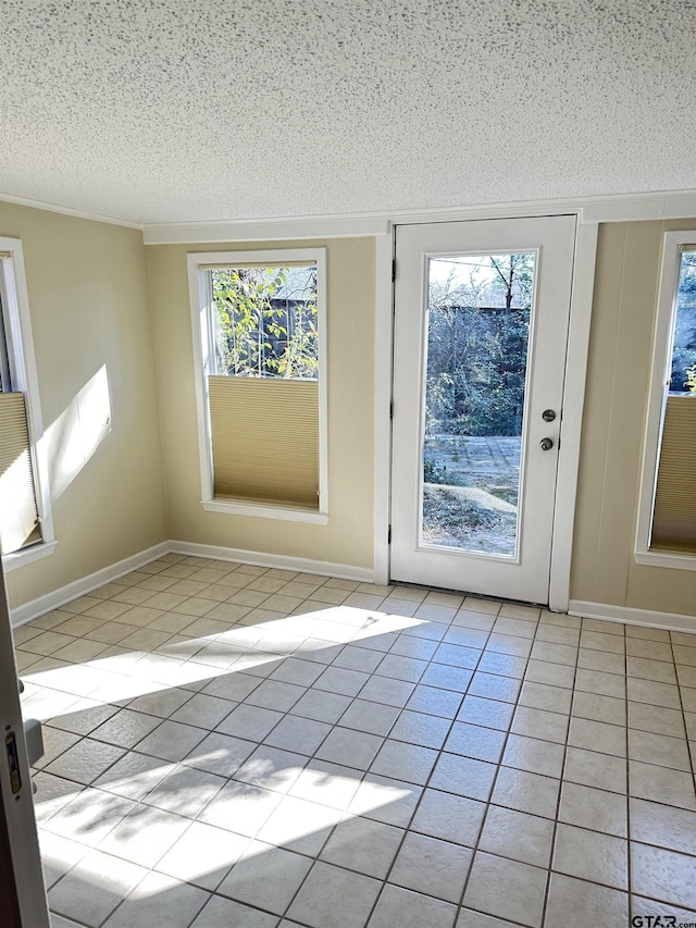 doorway to outside featuring a textured ceiling and light tile patterned floors