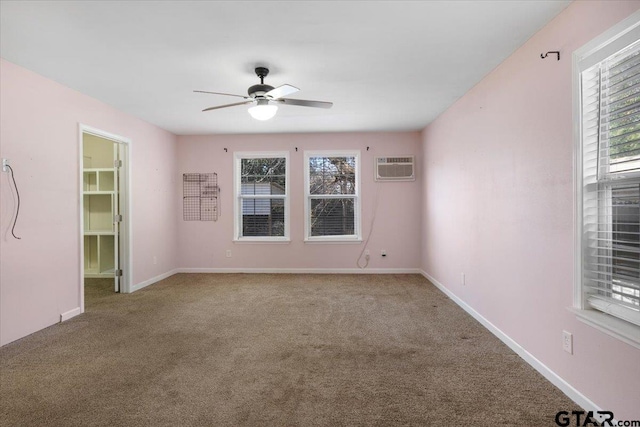 spare room featuring ceiling fan, a wall mounted AC, light colored carpet, and a healthy amount of sunlight