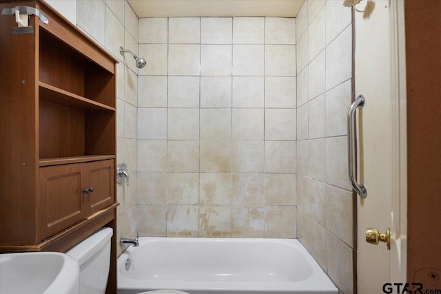 bathroom featuring toilet and tiled shower / bath