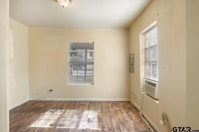 spare room featuring wood-type flooring, electric panel, and cooling unit