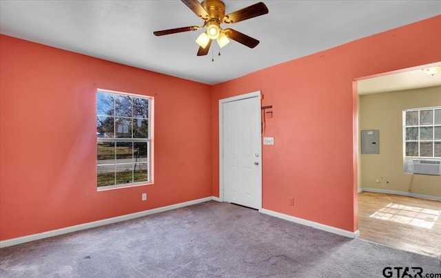 carpeted spare room with ceiling fan, cooling unit, and electric panel