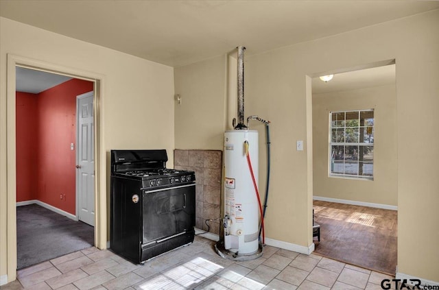 kitchen with black gas range oven, gas water heater, and light tile patterned floors