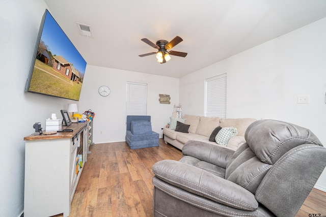 living room featuring light wood-style floors, ceiling fan, and visible vents