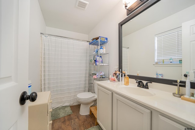 full bath featuring visible vents, a shower with shower curtain, toilet, vanity, and wood finished floors