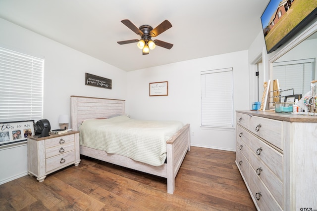 bedroom with dark wood-type flooring, baseboards, and a ceiling fan