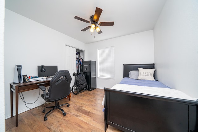 bedroom featuring light wood-type flooring, a ceiling fan, and a closet