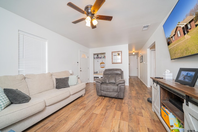 living room featuring ceiling fan, visible vents, and light wood-style floors