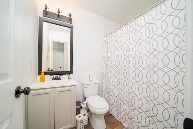 bathroom with wood finished floors, a shower with shower curtain, vanity, and toilet