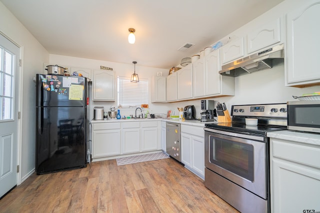 kitchen featuring light wood-style flooring, under cabinet range hood, a sink, visible vents, and appliances with stainless steel finishes