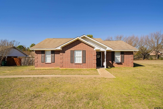 ranch-style home with brick siding, a front lawn, and fence