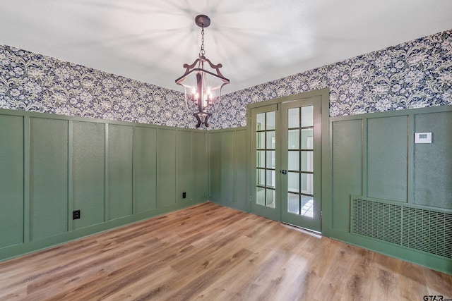 unfurnished dining area with french doors and light wood-type flooring