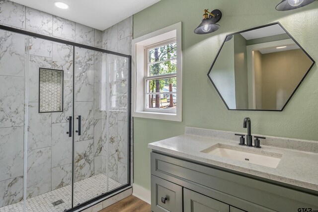 bathroom with vanity, wood-type flooring, and walk in shower