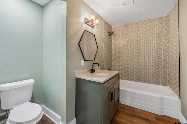 full bathroom featuring hardwood / wood-style floors, vanity, tiled shower / bath combo, and toilet