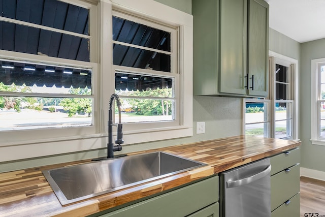 kitchen with wood counters, dishwasher, plenty of natural light, and green cabinetry