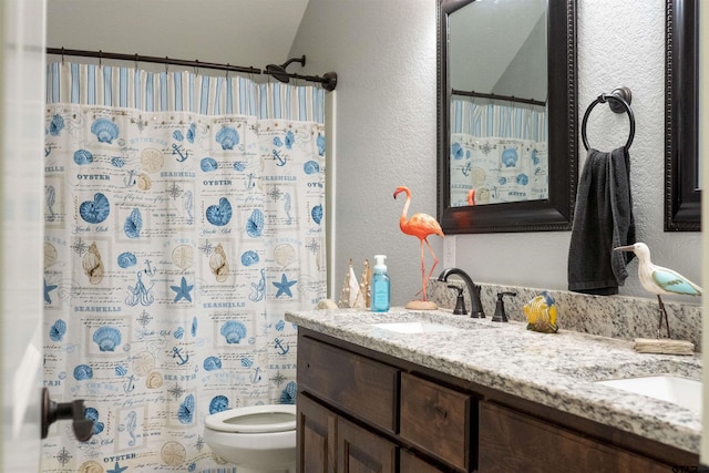 bathroom featuring a textured wall, toilet, curtained shower, a sink, and double vanity