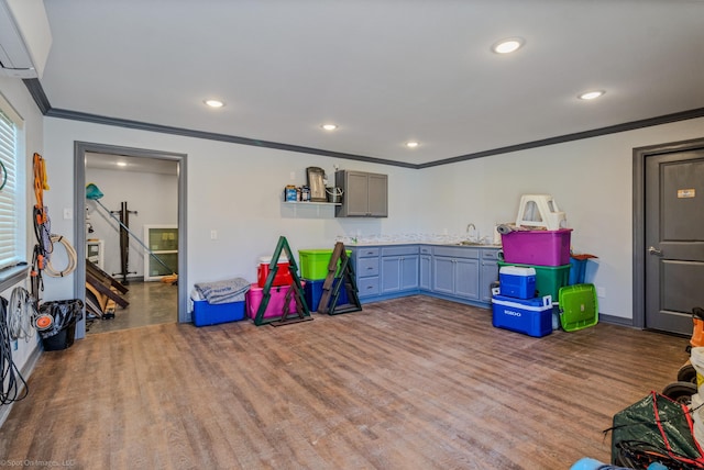 game room featuring hardwood / wood-style flooring, sink, and ornamental molding