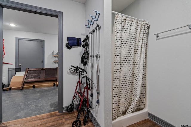 bathroom featuring wood-type flooring and walk in shower