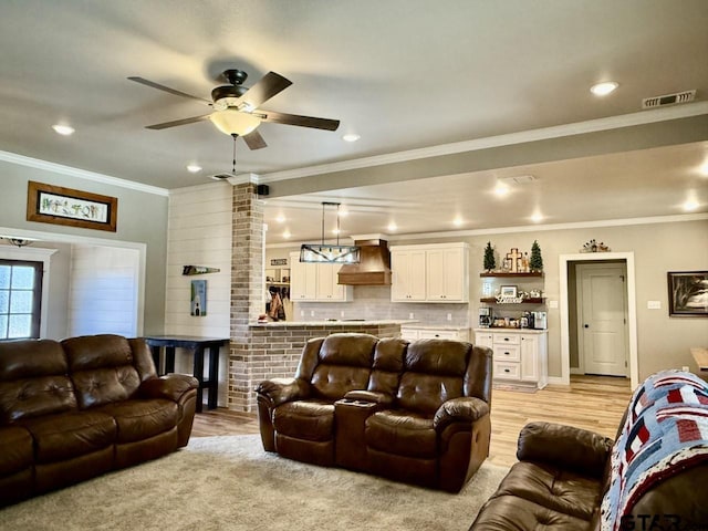 living room with ceiling fan and ornamental molding