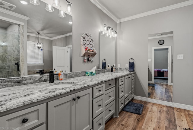 bathroom with hardwood / wood-style flooring, vanity, a shower with shower door, and crown molding