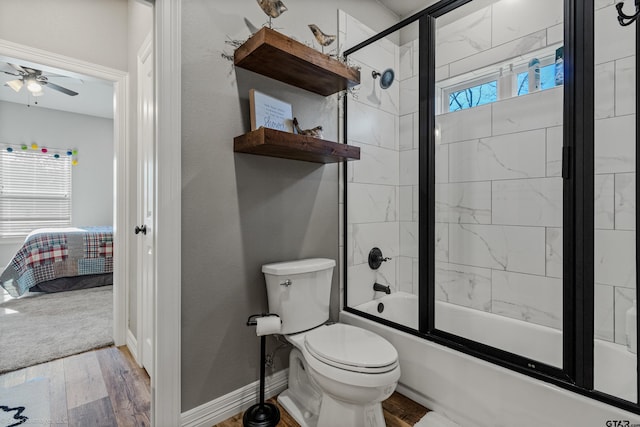 bathroom featuring ceiling fan, toilet, bath / shower combo with glass door, and wood-type flooring