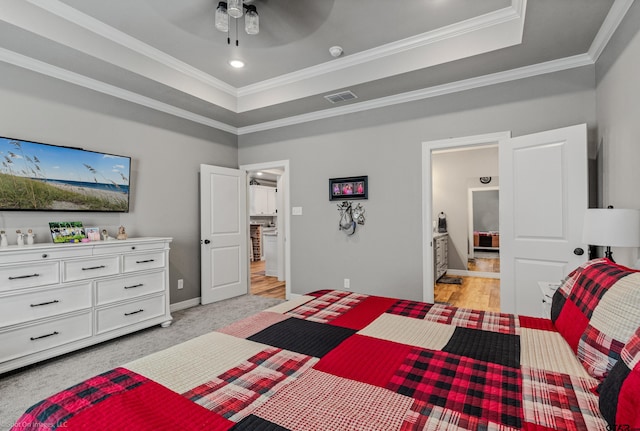 carpeted bedroom featuring ceiling fan, crown molding, and a tray ceiling