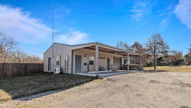 rear view of property with ac unit and a garage