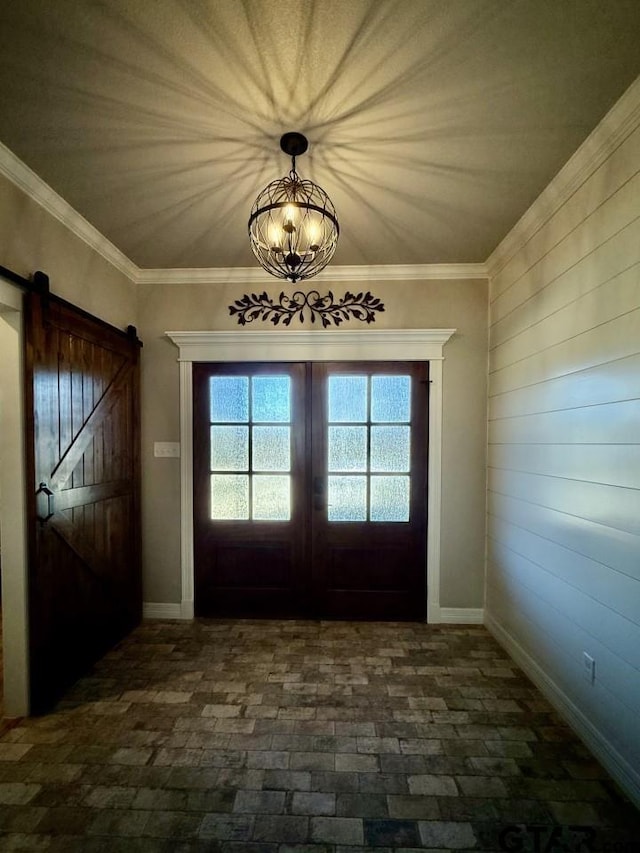 entryway with a barn door, ornamental molding, and french doors