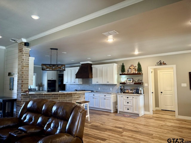 kitchen with decorative backsplash, custom range hood, pendant lighting, white cabinetry, and oven