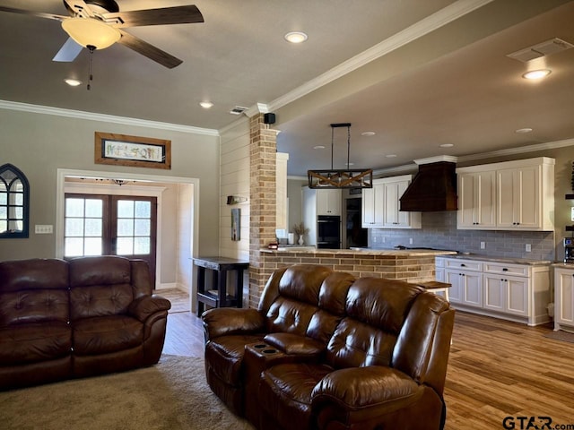 living room featuring light wood-type flooring, ceiling fan, and ornamental molding