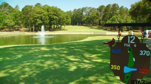 view of property's community with a lawn and a water view