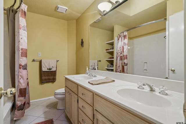 bathroom featuring tile patterned flooring, vanity, toilet, and a textured ceiling