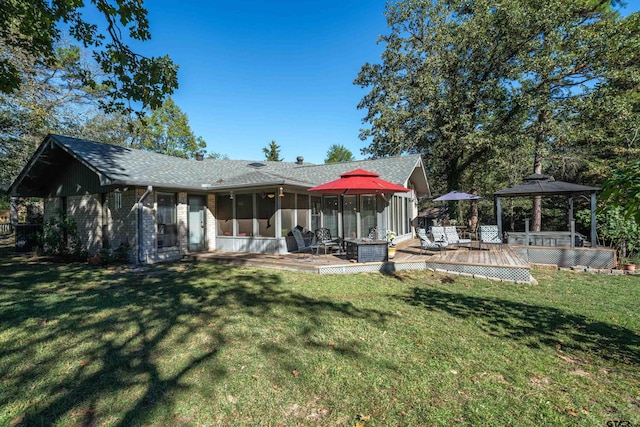 back of house with a gazebo, a sunroom, a lawn, and a deck