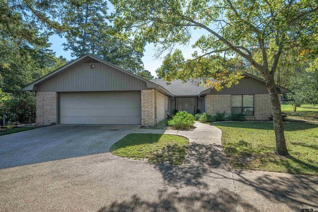 ranch-style house with a garage and a front lawn